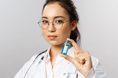 Portrait of young doctor against white background