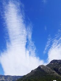 Low angle view of mountain against blue sky