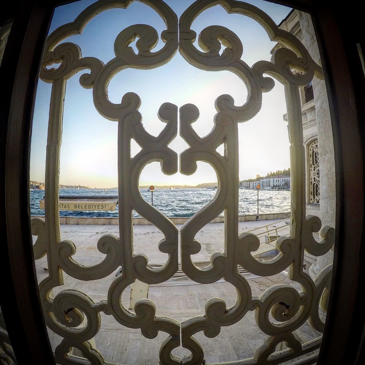 CLOSE-UP OF METALLIC RAILING AGAINST SEA