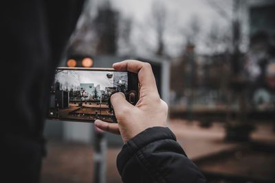 Close-up of person photographing camera on mobile phone