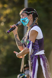 Side view of young woman holding umbrella