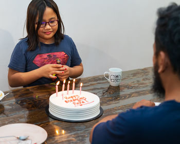 Girl looking at cake at home