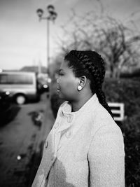 Woman looking away while standing outdoors