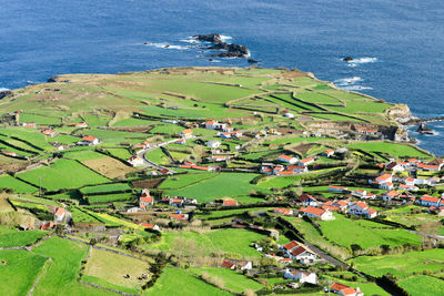 High angle view of houses by sea against sky