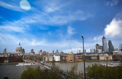 View of buildings at waterfront against cloudy sky