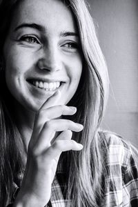 Close-up portrait of smiling young woman holding hair