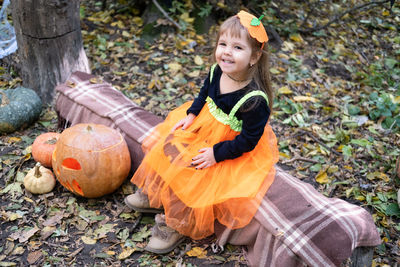 Halloween. cute little girl in pumpkin costume having fun, celebrating halloween outdoor