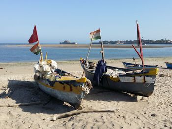 Deck chairs on beach against sky