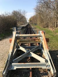 Railroad tracks on field against sky