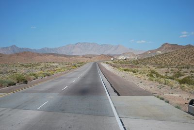 Empty road with mountains in background