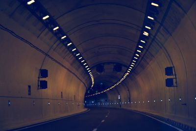 Empty road with lit ceiling lights in subway