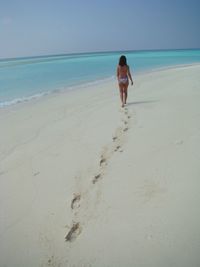 Rear view of girl walking on beach