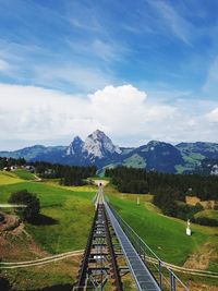 Railroad track amidst field against sky