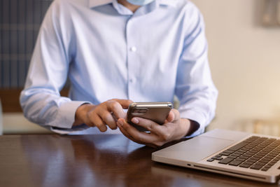 Midsection of man using mobile phone