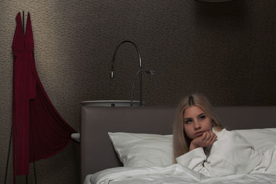 Portrait of woman relaxing on bed at home