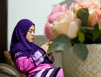 Woman wearing hijab while sitting at home