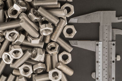 High angle view of nuts and bolts with ruler on table