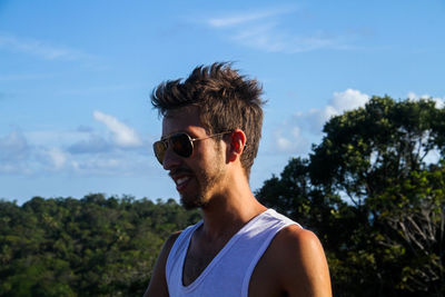 Smiling man wearing sunglasses against sky