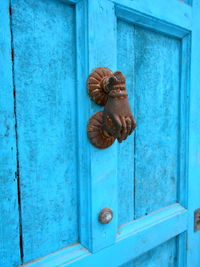 Hand shaped door knocker on blue door. ronda andalucia spain