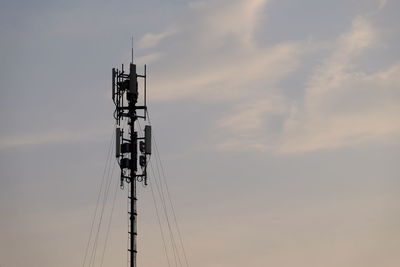 Low angle view of communications tower against sky during sunset