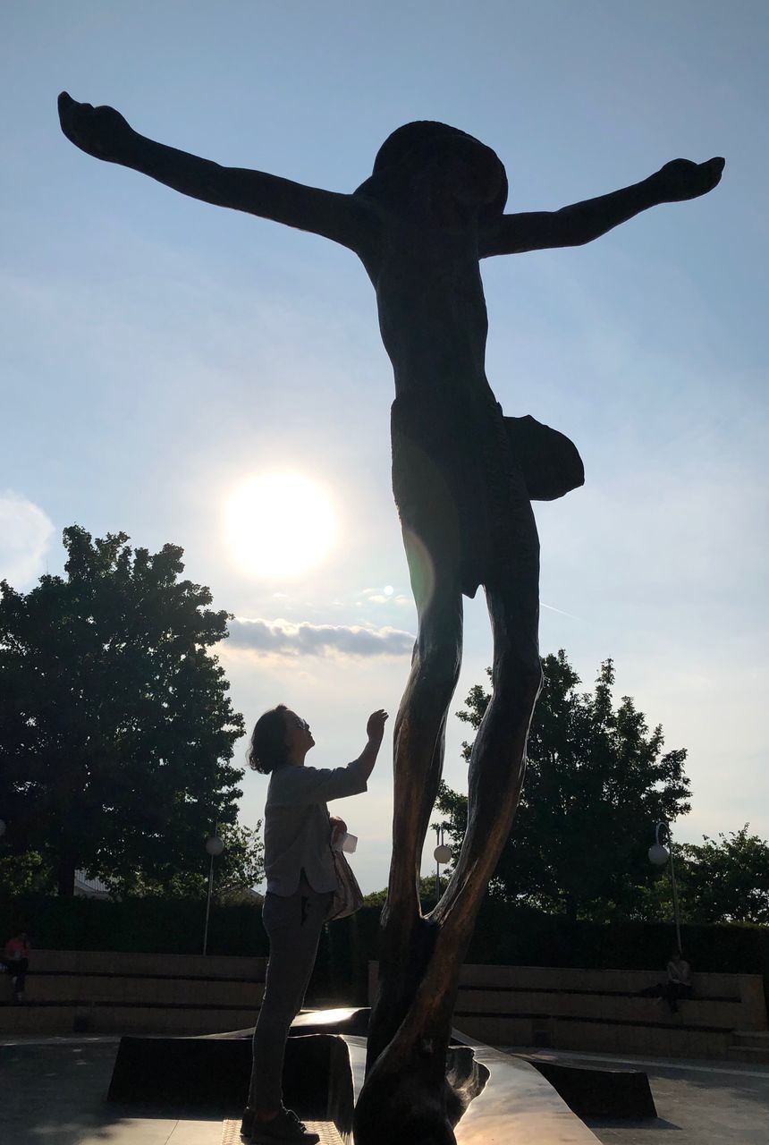 SILHOUETTE STATUE AGAINST TREES AND SKY