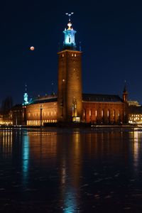 Blood moon over illuminated buildings stockholm city hall at night