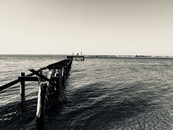 Pier on sea against clear sky