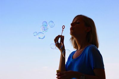 Low angle view of bubbles against blue sky