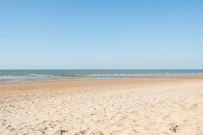 Scenic view of beach against clear blue sky