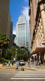 People on street by buildings in city