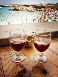 Close-up of beer in glass on table at beach