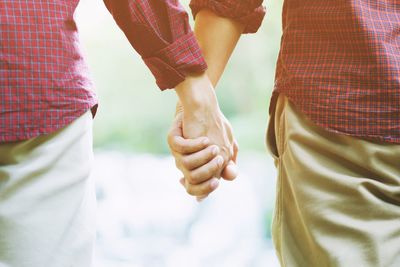 Midsection of couple holding hands