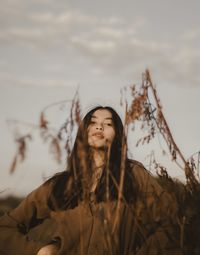 Portrait of a smiling young woman against sky