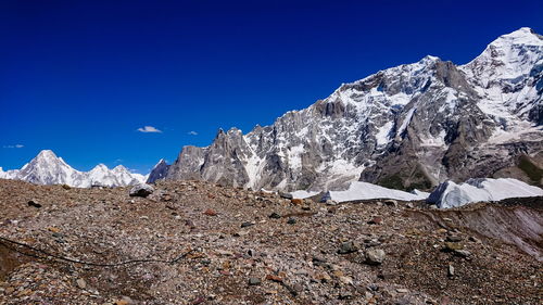 Scenic view of snowcapped mountains against clear blue sky