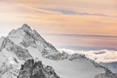 Scenic view of snowcapped mountains against sky during sunset