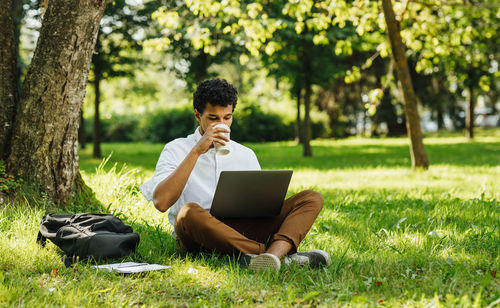 Young man using mobile phone in park