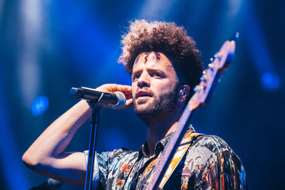 View of man with arms raised in music concert