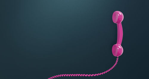 Close-up of pink balloons against wall against black background