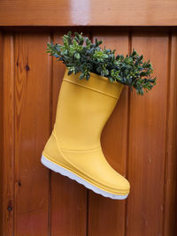 Wellington boot hanging from wood paneling