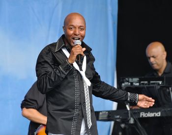 Portrait of man with arms raised standing on stage