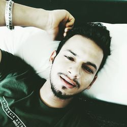 Portrait of young man lying down on bed