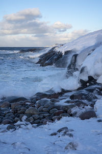 Scenic view of rocks in sea against sky