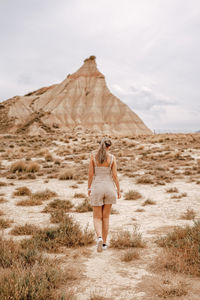 Full length rear view of woman walking on field