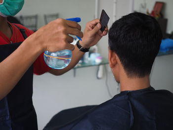 Midsection of barber cutting hair of customer