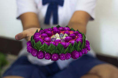 Midsection of woman showing flower basket during loi krathong