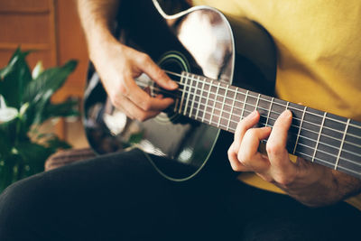 Midsection of man playing guitar