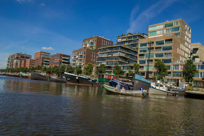 Boats moored in city against sky