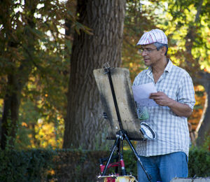 Painter standing by tree