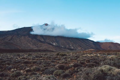 Smoke emitting from volcanic mountain against sky