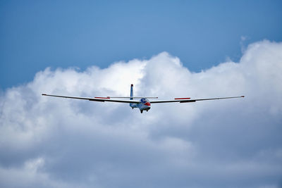 Low angle view of airplane flying against sky